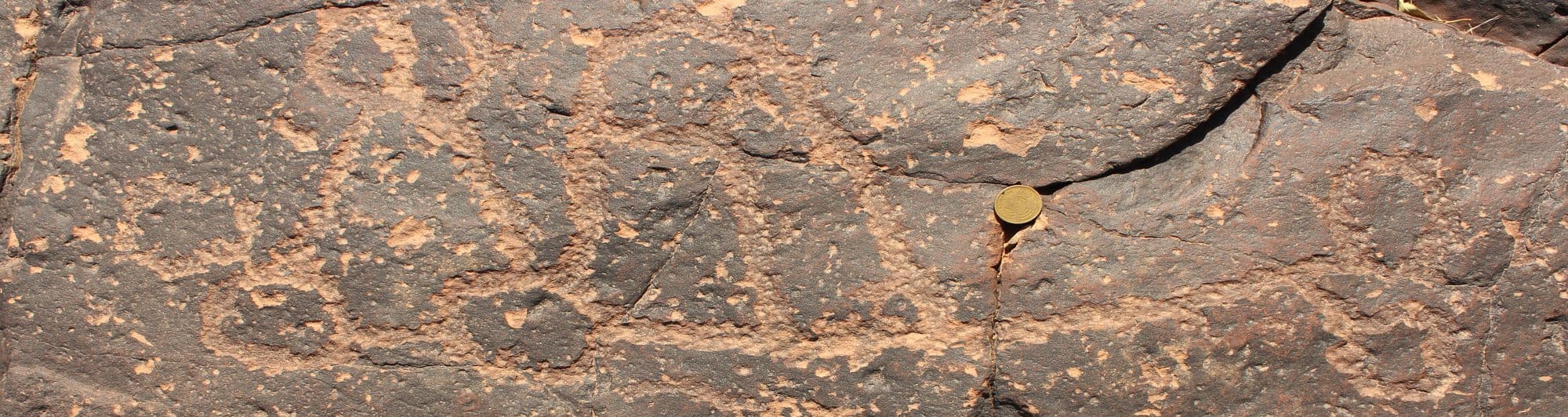 Ancient rock engraving on a dark sandstone surface